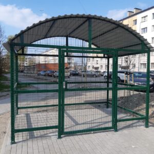 Avfallscontainerplass med buet tak. Kodelås. Kledning i metallnett. Konstruksjonen kan flyttes ved behov. Beregnet for 2 store og 2 små avfallscontainere.