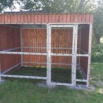Avfallscontainerplass med trepanel og metallnett