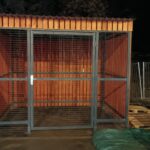 Avfallscontainerplass med trepanel og metallnett