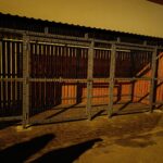 Avfallscontainerplass med trepanel og metallnett